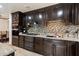 Modern kitchen with granite countertops, dark cabinets, stainless steel appliances, and tile backsplash at 2942 E Mulberry Dr, Phoenix, AZ 85016