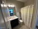 A bathroom with a shower, toilet, and a sink with a dark-colored vanity at 29573 W Mitchell Ave, Buckeye, AZ 85396