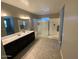 Spacious bathroom featuring double sinks, a vanity, and a glass door walk-in shower at 29573 W Mitchell Ave, Buckeye, AZ 85396