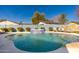 Backyard pool with a stone waterfall feature, manicured landscaping, and outdoor seating area, perfect for relaxation at 3312 E Sells Dr, Phoenix, AZ 85018