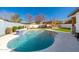 Sparkling pool in a private backyard, complete with outdoor kitchen, pergola, and lush landscaping, ideal for entertaining at 3312 E Sells Dr, Phoenix, AZ 85018