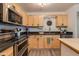 Modern kitchen with stainless steel appliances, wood cabinets, and a central island at 3350 W Charter Oak Rd, Phoenix, AZ 85029