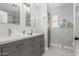 Stylish bathroom featuring a double vanity with gray cabinets, marble countertops, and decorative lighting fixtures at 337 E Clairidge Dr, San Tan Valley, AZ 85143