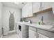 Well-lit laundry room with side-by-side washer and dryer, white cabinets, and a sink at 337 E Clairidge Dr, San Tan Valley, AZ 85143