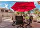 Outdoor patio featuring a red umbrella, seating area, fire pit, and well-maintained landscaping at 337 E Clairidge Dr, San Tan Valley, AZ 85143