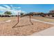 Community playground featuring swings, wood chip ground cover, and surrounding desert landscape at 337 E Clairidge Dr, San Tan Valley, AZ 85143