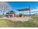 Community playground featuring a covered gazebo, playground equipment, and desert surroundings at 337 E Clairidge Dr, San Tan Valley, AZ 85143