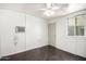 Simple room with a ceiling fan, window air conditioning unit, and dark laminate flooring at 354 W Bealey Ave, Coolidge, AZ 85128