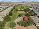 An aerial view shows a community park with lots of green space and a playground surrounded by homes at 37056 W Prado St, Maricopa, AZ 85138