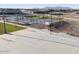 Community basketball court with hoops and benches against a backdrop of new homes at 37056 W Prado St, Maricopa, AZ 85138