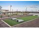 Cornhole and seating are available in the community game space with beautiful landscaping and walking path at 37056 W Prado St, Maricopa, AZ 85138