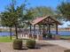 Covered gazebo near a pond with seating and views of the surrounding green spaces at 37056 W Prado St, Maricopa, AZ 85138