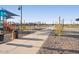 Community playground with shade, picnic tables, and a walking path on a clear day at 37056 W Prado St, Maricopa, AZ 85138