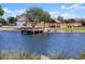 Community pond with a pier and a covered gazebo, surrounded by mature trees at 37056 W Prado St, Maricopa, AZ 85138