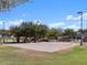 Inviting sand volleyball court shaded by mature trees, perfect for leisurely games and outdoor fun at 37056 W Prado St, Maricopa, AZ 85138