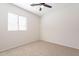 A bright bedroom features a ceiling fan and neutral carpet at 38672 N Establo Dr, San Tan Valley, AZ 85140