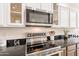 Close-up of a modern kitchen featuring stainless steel appliances, granite countertops, and white cabinets at 38672 N Establo Dr, San Tan Valley, AZ 85140