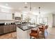 Modern kitchen with an island, bar seating, pendant lighting, stainless appliances, and white cabinetry at 38672 N Establo Dr, San Tan Valley, AZ 85140