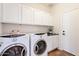 Laundry room includes cabinets and modern washer and dryer at 38672 N Establo Dr, San Tan Valley, AZ 85140