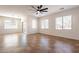 Bright and airy living room featuring tile flooring, a ceiling fan, and large windows at 38672 N Establo Dr, San Tan Valley, AZ 85140