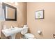 Neutral-toned bathroom featuring a pedestal sink, a framed mirror, and artwork adding a touch of elegance at 3881 E Birchwood Pl, Chandler, AZ 85249