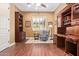 Elegant home office featuring built-in bookcases, a comfortable armchair, and ample workspace at 3881 E Birchwood Pl, Chandler, AZ 85249