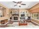 Living room features stone fireplace, a ceiling fan, and built-in bookshelves at 3881 E Birchwood Pl, Chandler, AZ 85249