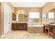 Inviting bathroom showcasing a vanity, soaking tub with tile surround, and natural light from a window at 3881 E Birchwood Pl, Chandler, AZ 85249