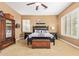 Well-lit main bedroom featuring neutral carpeting, a ceiling fan, and shuttered windows for privacy at 3881 E Birchwood Pl, Chandler, AZ 85249