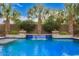 Lush landscaping highlights the backyard pool with a charming waterfall feature at 3881 E Birchwood Pl, Chandler, AZ 85249