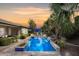 Backyard swimming pool featuring palm trees, seating, and a soothing waterfall at 3881 E Birchwood Pl, Chandler, AZ 85249