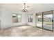 Bright dining room with tile flooring, neutral walls, a chandelier, and sliding glass door to patio at 39242 N Luke Cir, San Tan Valley, AZ 85140