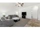 Open concept living room with plush gray seating, bright lighting, and tile entry flooring at 39242 N Luke Cir, San Tan Valley, AZ 85140