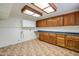 Expansive laundry room equipped with storage cabinets, counter space, and tile flooring for practicality at 3938 E Gable Ave, Mesa, AZ 85206