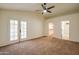 Tastefully staged main bedroom boasts ceiling fan, carpet flooring, French door access, ensuite bathroom and walk-in closet at 3938 E Gable Ave, Mesa, AZ 85206