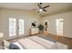 Tastefully staged main bedroom boasts ceiling fan, carpet flooring, French door access, ensuite bathroom and walk-in closet at 3938 E Gable Ave, Mesa, AZ 85206