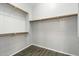 Walk-in closet provides ample storage space, wood-look tile flooring, and built-in shelving at 40504 N Territory Trl, Anthem, AZ 85086