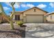 Charming single-story home featuring a two-car garage, desert landscaping and blue sky at 40504 N Territory Trl, Anthem, AZ 85086