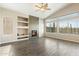 Bright living room with fireplace, built-in shelves, wood-look tile flooring, and large picture window at 40504 N Territory Trl, Anthem, AZ 85086