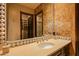 Elegant bathroom featuring a decorative mirror and a doorway leading to closet and shower at 42237 N 107Th Pl, Scottsdale, AZ 85262