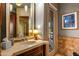 Bathroom featuring a large mirror, stone countertops, wood cabinetry, and glass door to the outside at 42237 N 107Th Pl, Scottsdale, AZ 85262