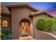 Exterior shot featuring an arched entryway with double doors, tiled roof and landscaped garden at 42237 N 107Th Pl, Scottsdale, AZ 85262