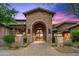 Elegant front entrance showcasing stone archway, wrought iron gate, and desert landscaping at 42237 N 107Th Pl, Scottsdale, AZ 85262