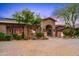 Stunning home with lush landscaping, stone accents, and a charming arched entrance at 42237 N 107Th Pl, Scottsdale, AZ 85262