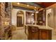 A gourmet kitchen features dark wood cabinetry, granite counters, stainless appliances, and stone detailing at 42237 N 107Th Pl, Scottsdale, AZ 85262