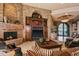 Cozy living room showcasing a stone fireplace, entertainment center, and plush furnishings at 42237 N 107Th Pl, Scottsdale, AZ 85262