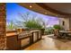 This outdoor kitchen boasts a built-in grill, countertop space, and stainless steel appliances on the covered patio at 42237 N 107Th Pl, Scottsdale, AZ 85262