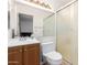 Standard bathroom featuring a glass enclosed shower, single sink vanity, toilet, and a large mirror at 4401 W Lewis Ave, Phoenix, AZ 85035