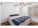 Bright bedroom featuring a ceiling fan, a bed with decorative blanket, and a window at 4401 W Lewis Ave, Phoenix, AZ 85035