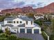 An aerial view of a white home, with a grey roof, a three-car garage, and a mountain backdrop at 4716 N Dromedary Rd, Phoenix, AZ 85018